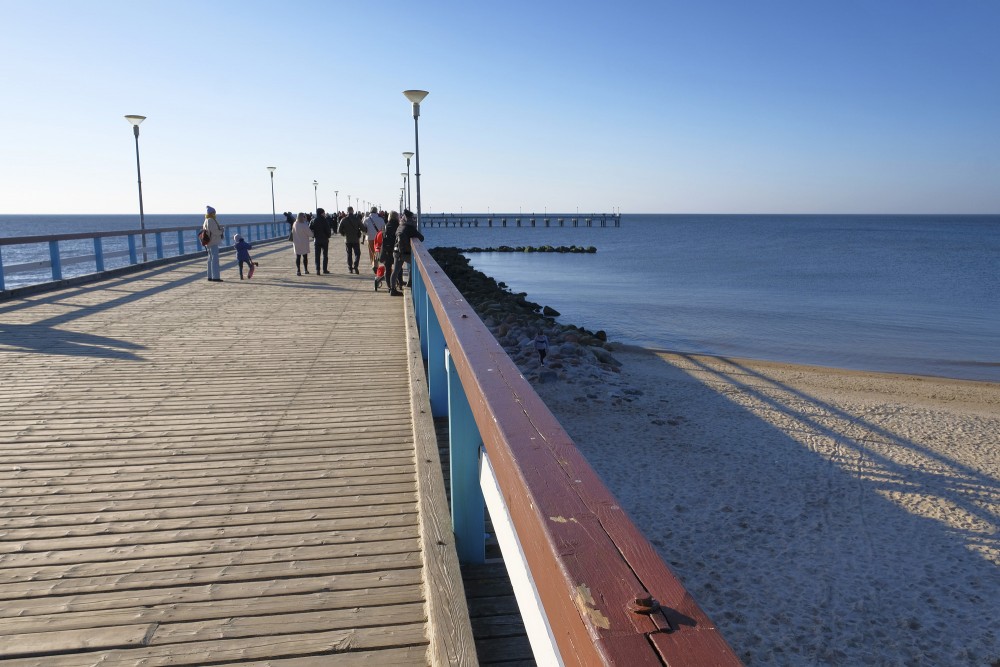 Walking on Palanga Sea Pier with views of the beach and calm sea