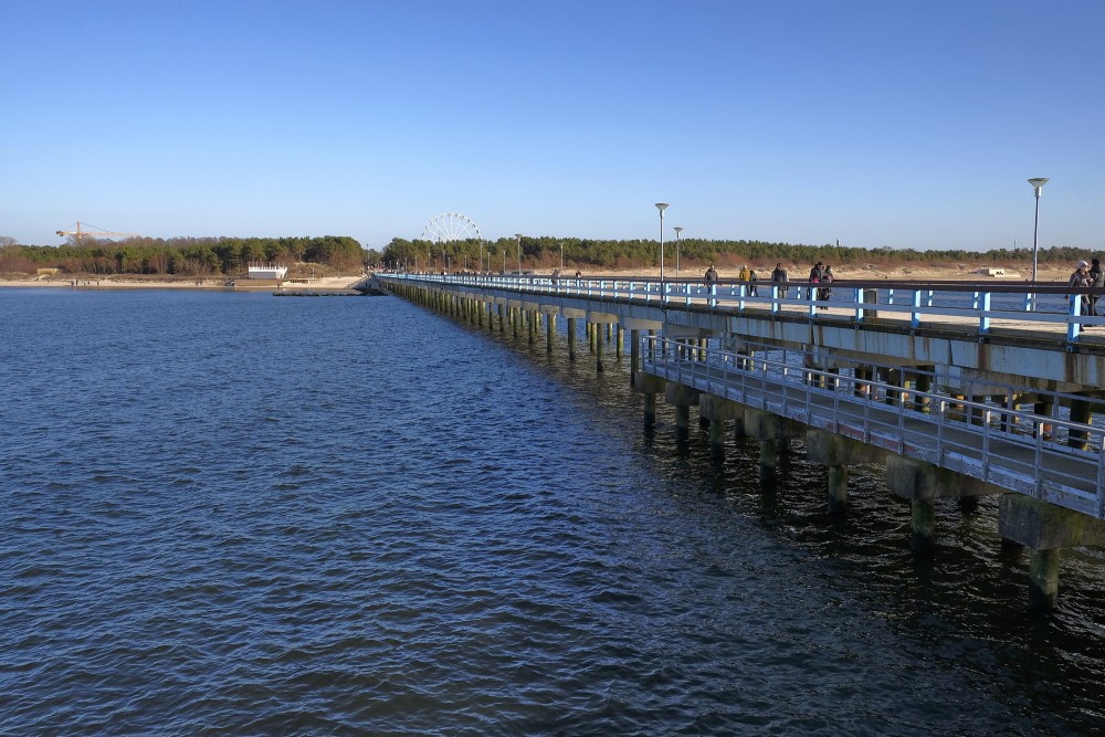View along Palanga Sea Pier over the water with coastline and people