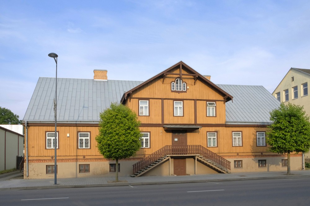 Koka ēka Marijampolē ar dekoratīvu fasādi un kāpnēm