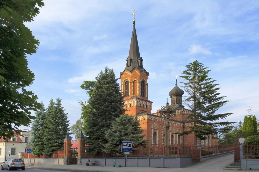 Marijampoles baznīcas tornis un sīpolkupols ar krucifiksu priekšplānā Marijampoles baznīcas tornis un sīpolkupols ar krucifiksu priekšplānā