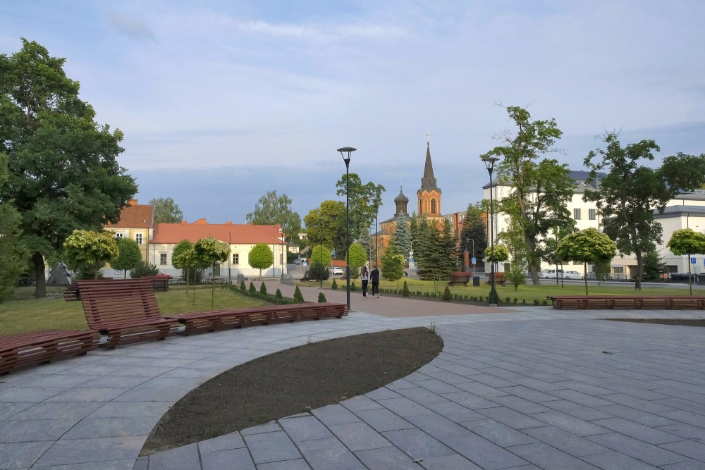 Marijampoles pilsētas skvērs ar baznīcas torni tālumā