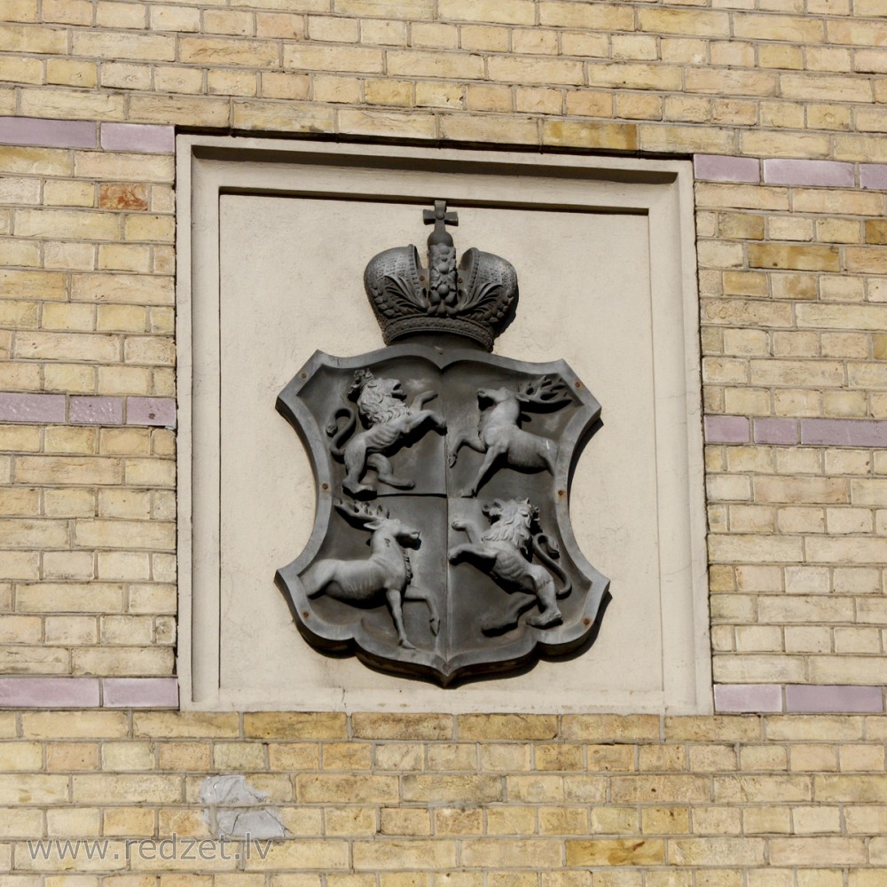 Ģerbonis ēkas fasādē (Raiņa bulvāris 19)