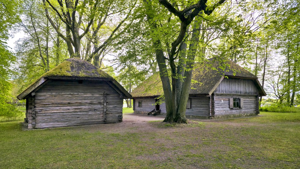 Ancient wooden outbuildings and a residential house in the yard of the Daugava Museum