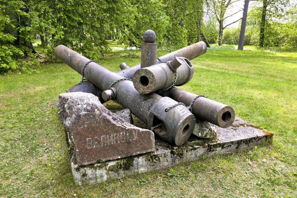 Historical coastal artillery cannon barrels with a commemorative stone at the Daugava Museum