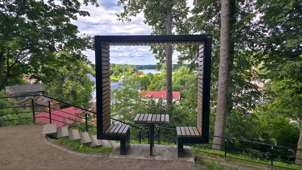 Stylized wooden frame "Frame Talsi" with a scenic town and lake view