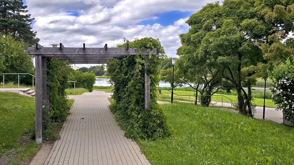 Koka pergola un bruģēts celiņš pie Vilkmuižas ezera Talsos