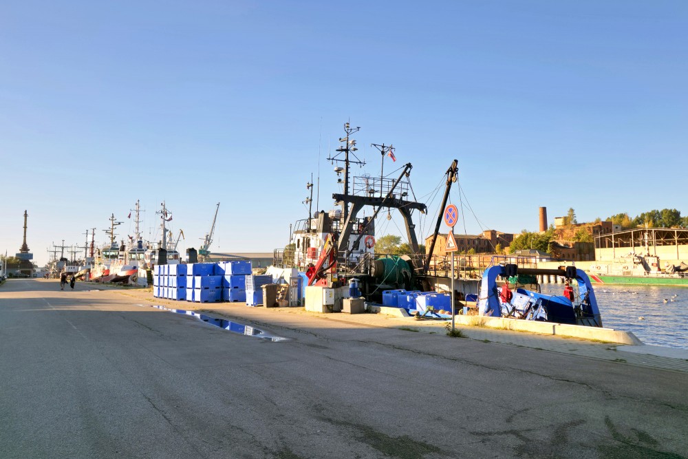 Fishing vessels and blue fish crates at Liepaja port quay