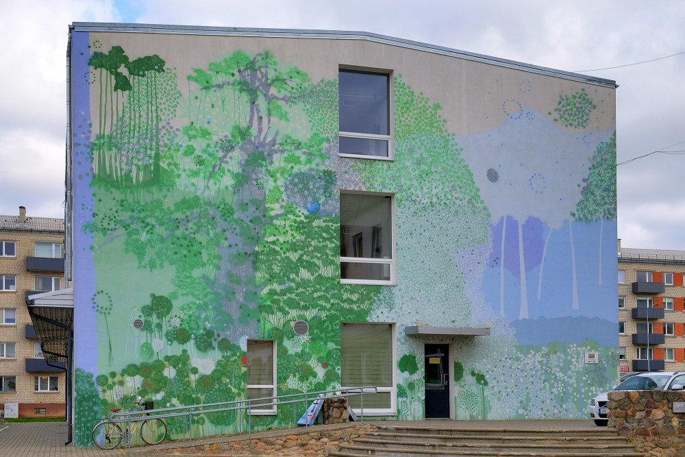 Apartment building mural with stylized forest landscape