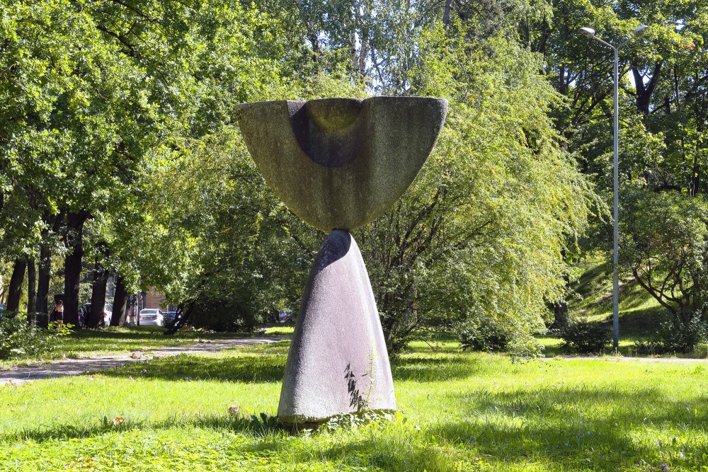 Abstract stone sculpture in a tree-filled urban park
