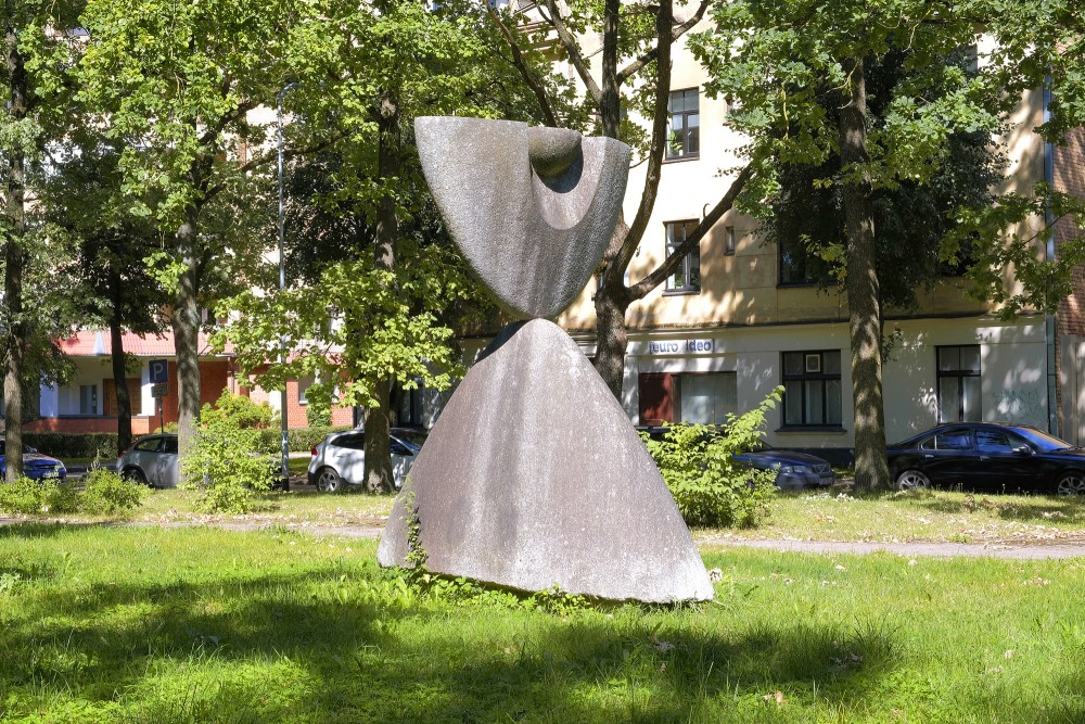 Monumental stone sculpture in an urban park among trees