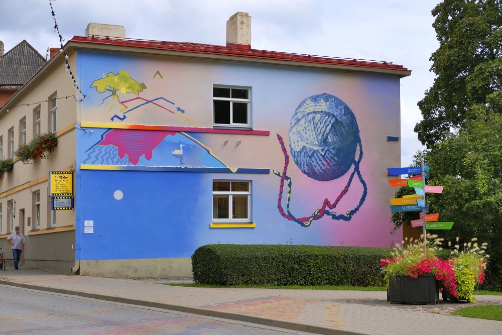 Colorful mural with a yarn ball on a building facade in Talsi
