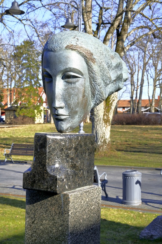 Bronzas skulptūras galva uz akmens pamatnes Palangas skulptūru dārzā