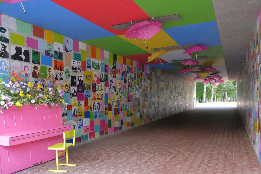Colorful pedestrian tunnel with portrait wall and piano in Marijampolė